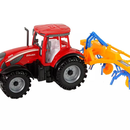 Raudonas traktorius su grėbliu