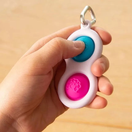 Sensorinis žaislas - raktų pakabukas „Simpl Dimpl“ (įvairių spalvų)